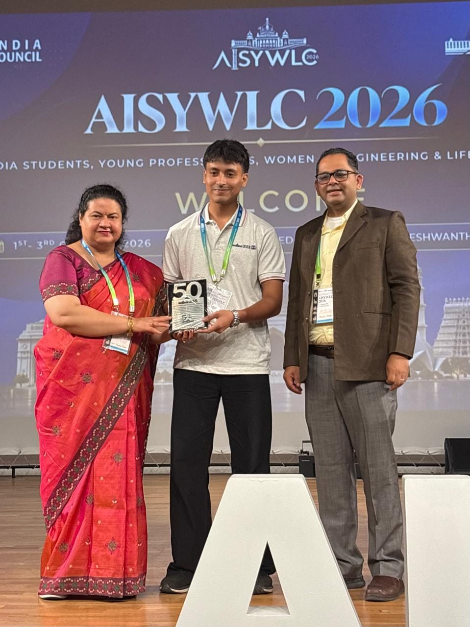 Sahil Pawar receiving an award plaque on stage at AISYWLC 2026